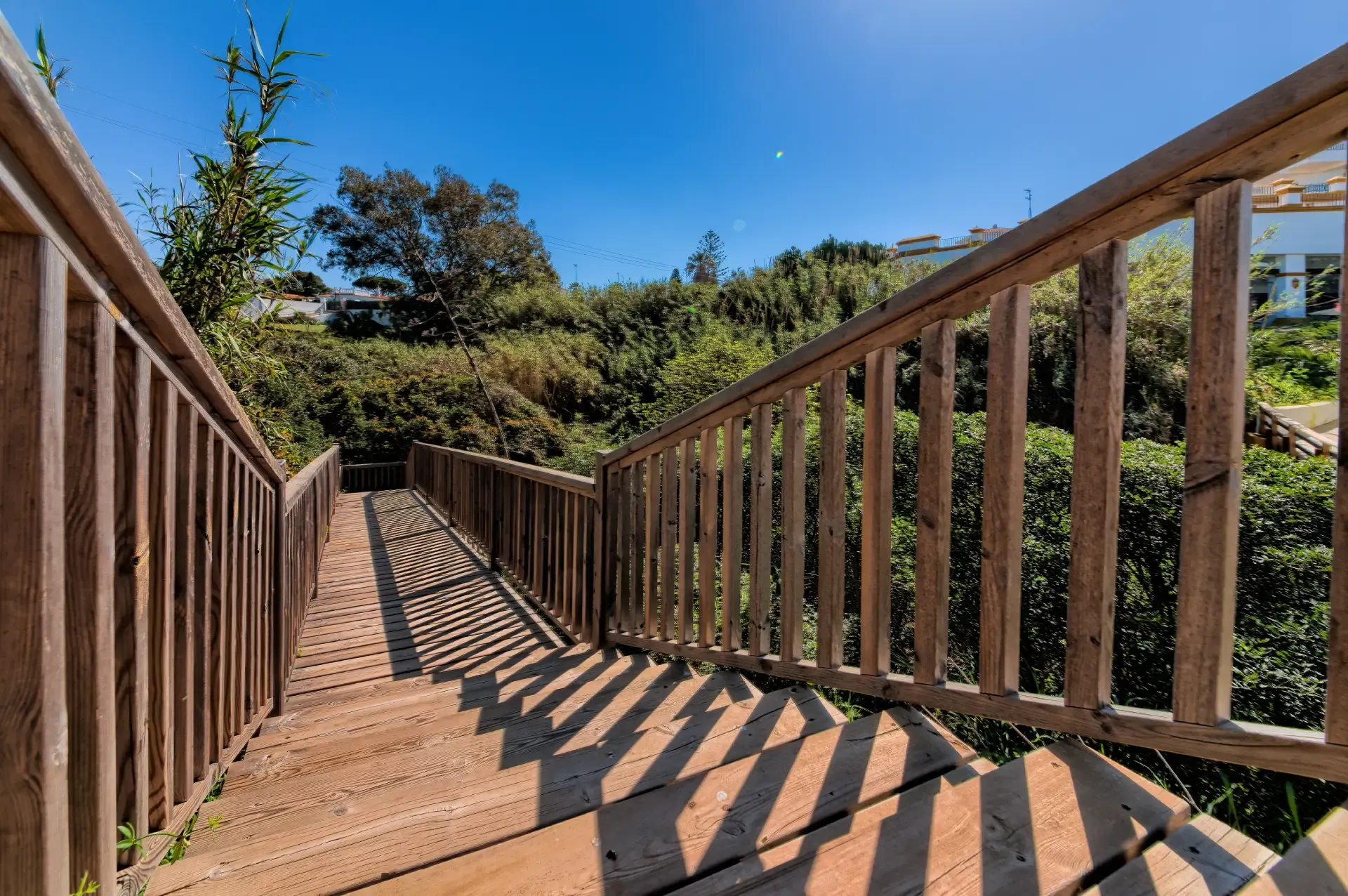 Pasarela de madera que baja desde las villas hasta la playa