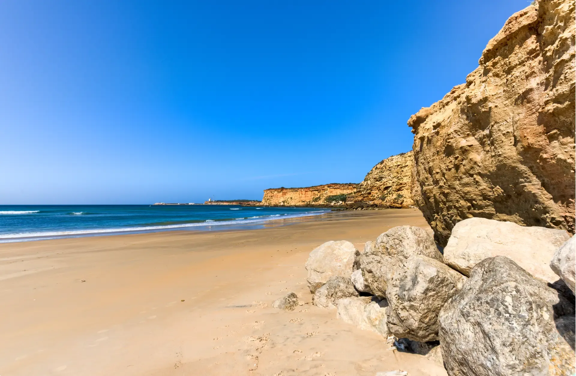 Playa de arena dorada bajo acantilados en Conil