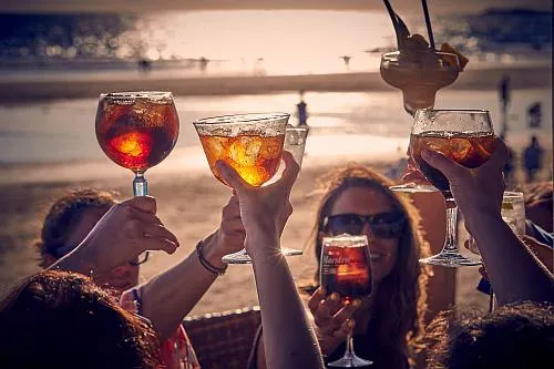 Drinks bei Sonnenuntergang im Chiringuito Feduchy Playa am Strand La Fontanilla